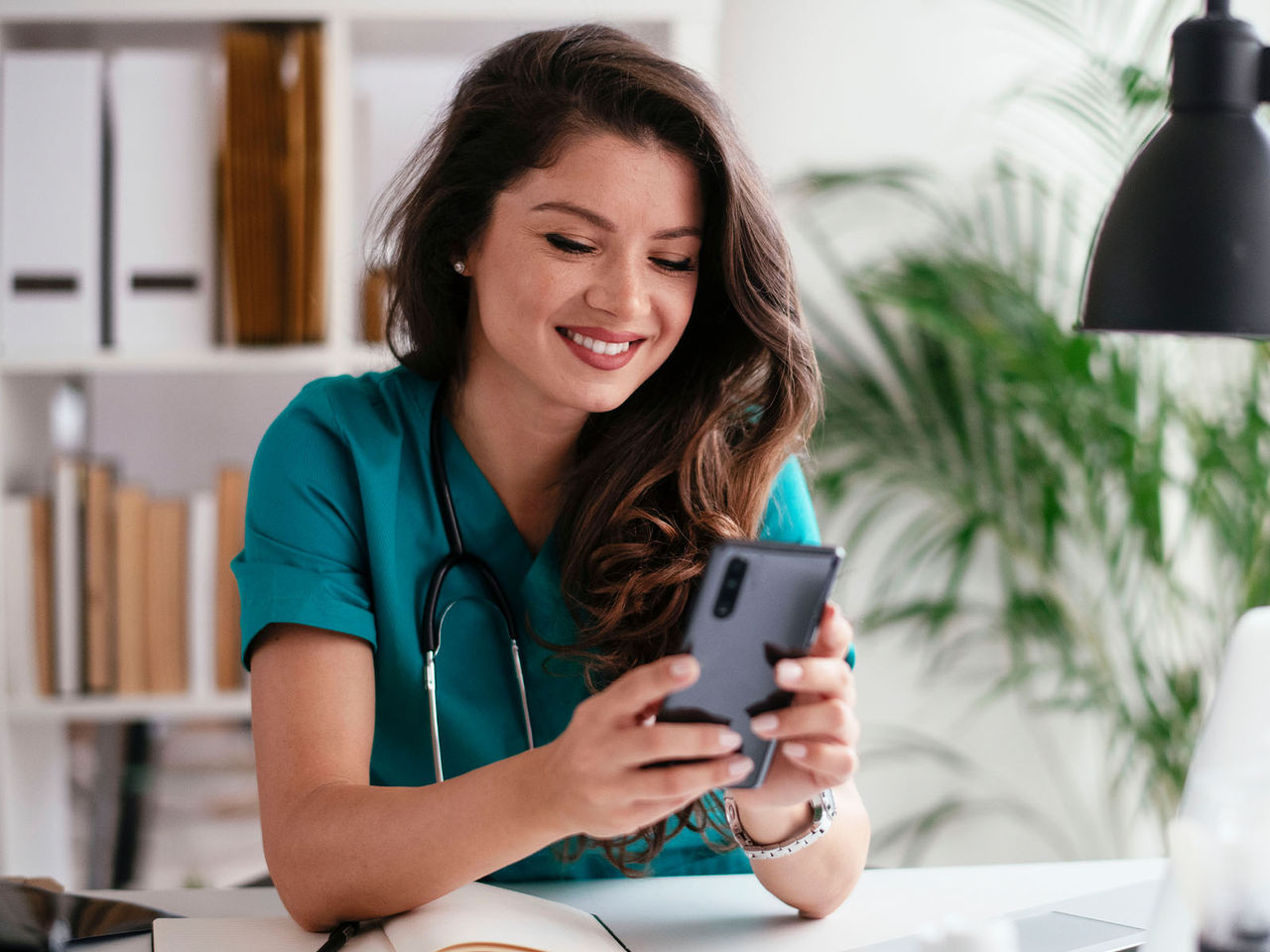 Profesional de la salud usando un teléfono celular.​​ 