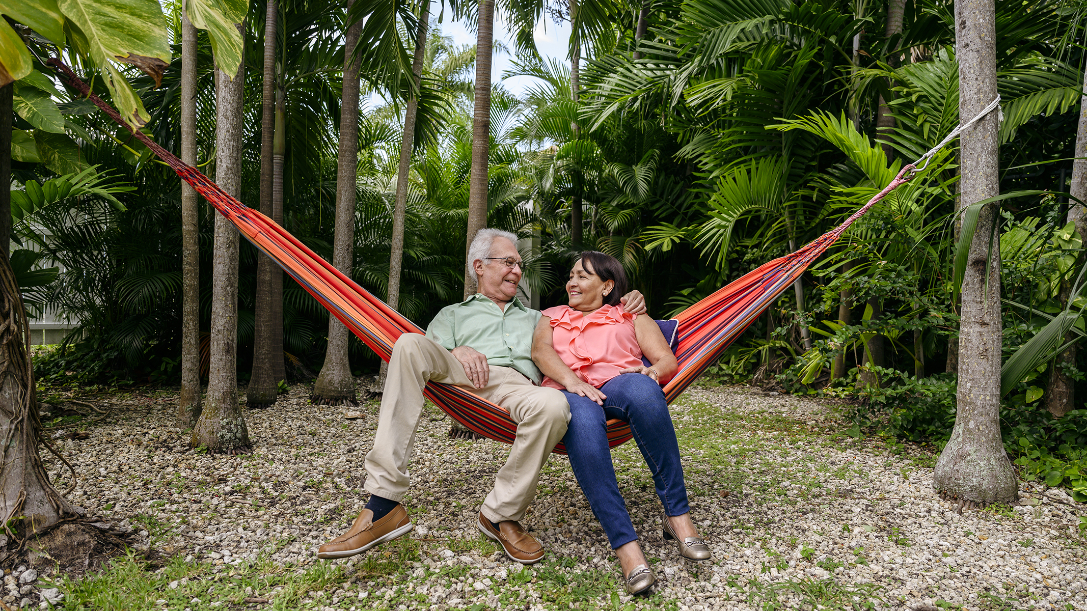 Pareja de personas mayores relajándose en una hamaca​​ 