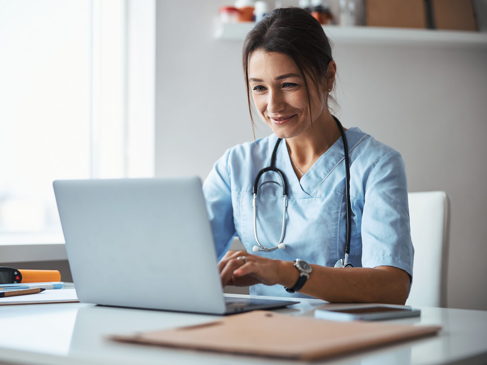 Una profesional de cuidado de la salud utilizando un computador portátil.​​ 