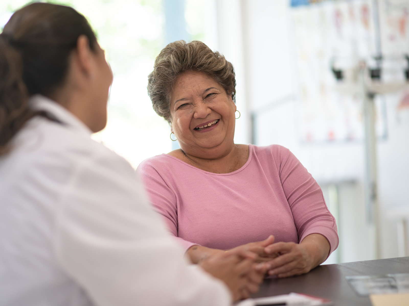 Mujer mayor hablando con una médica.​​  