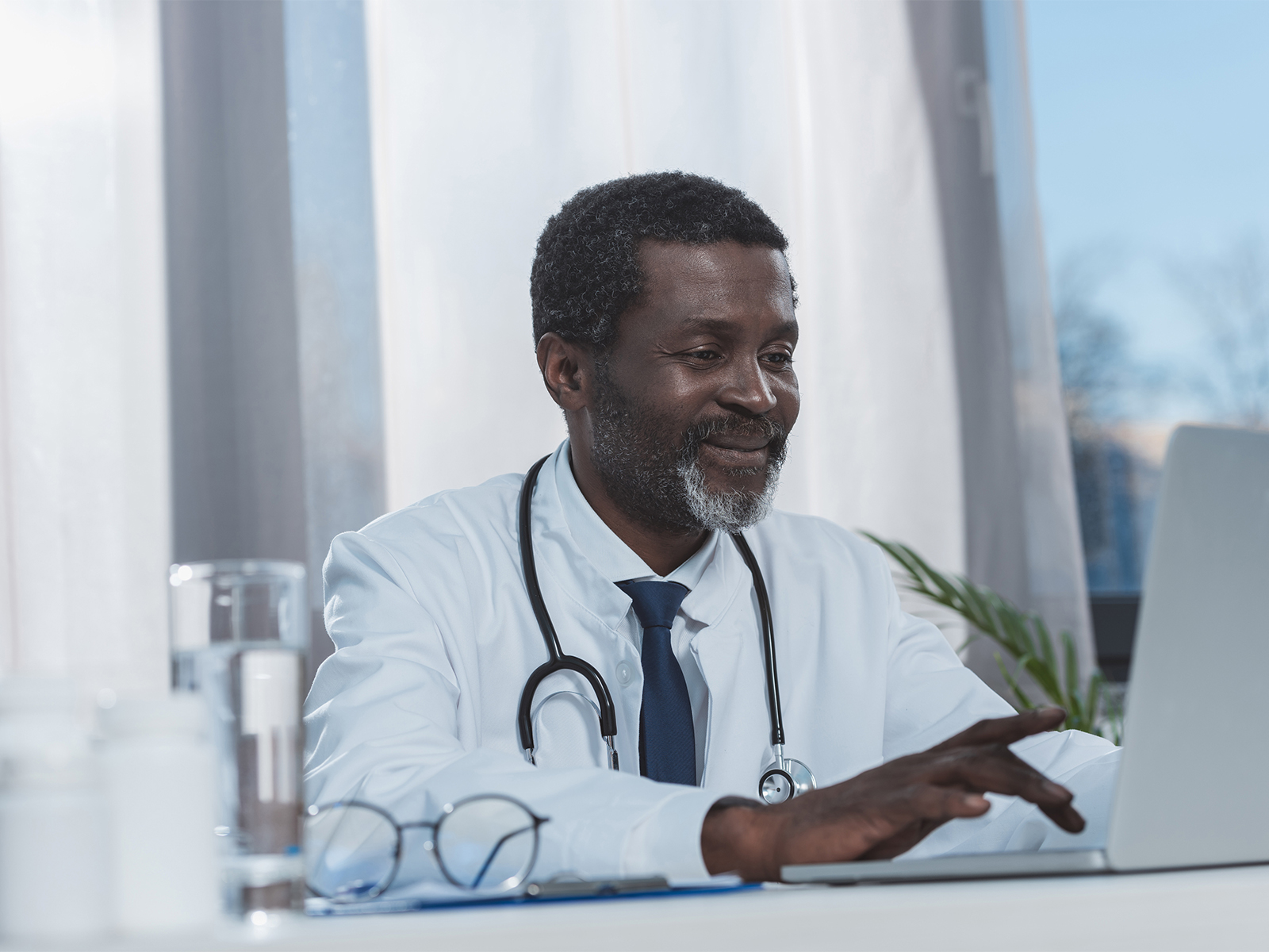 Médico usando un computador portátil.​​ 