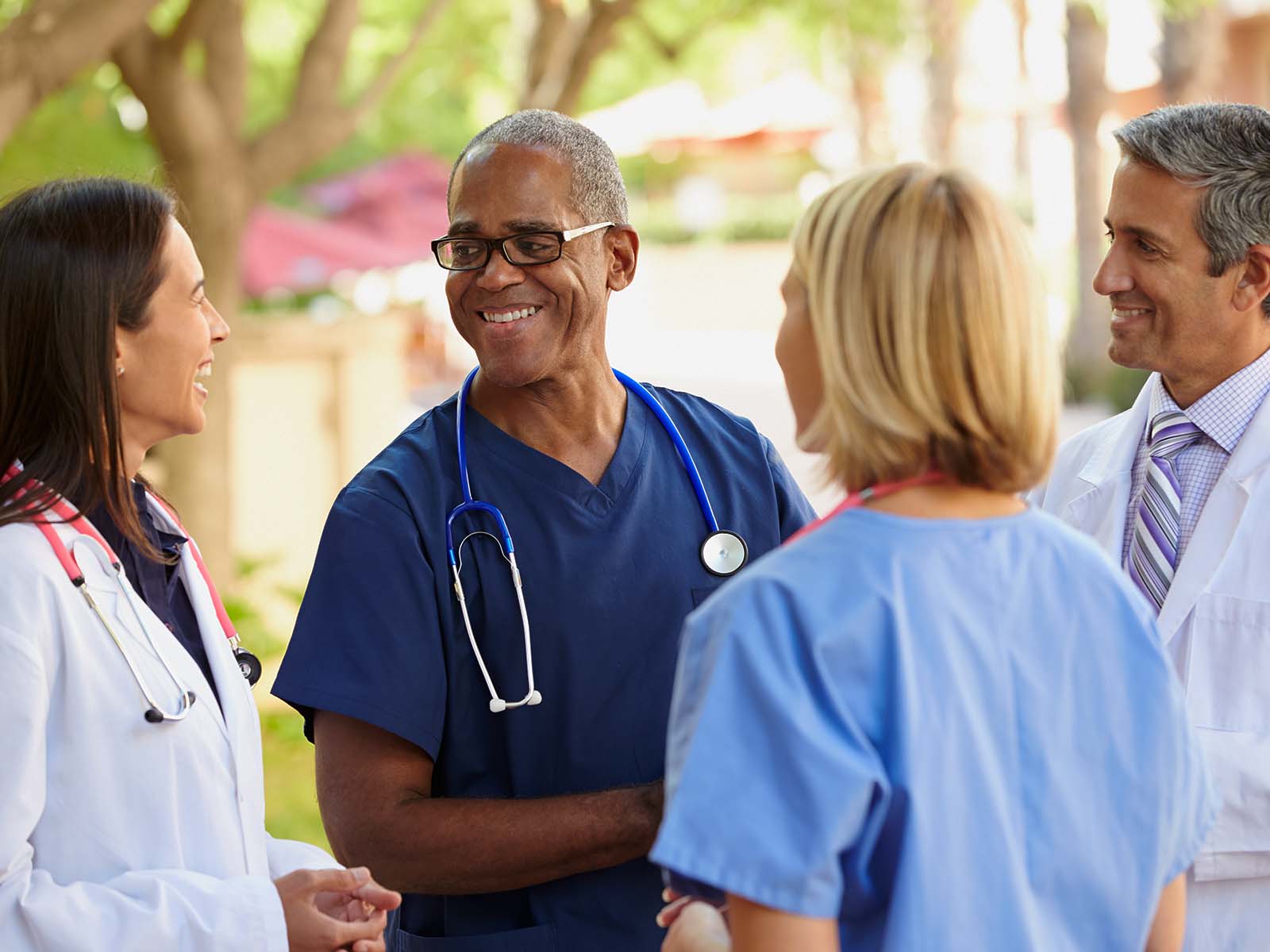 Grupo de proveedores de cuidado de la salud conversando.​​  
