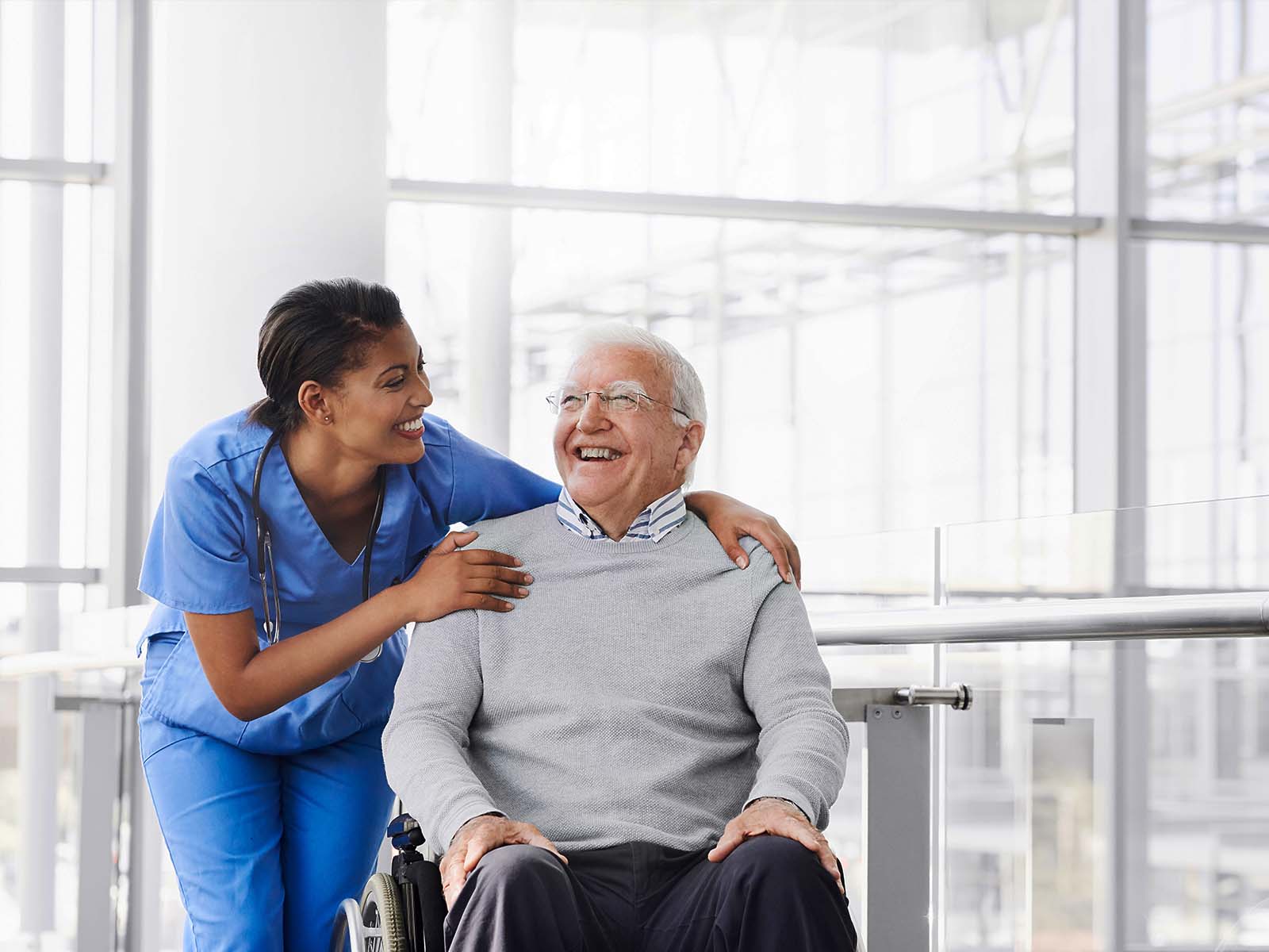 Hombre mayor y profesional de cuidado de la salud sonriendo.​​ 