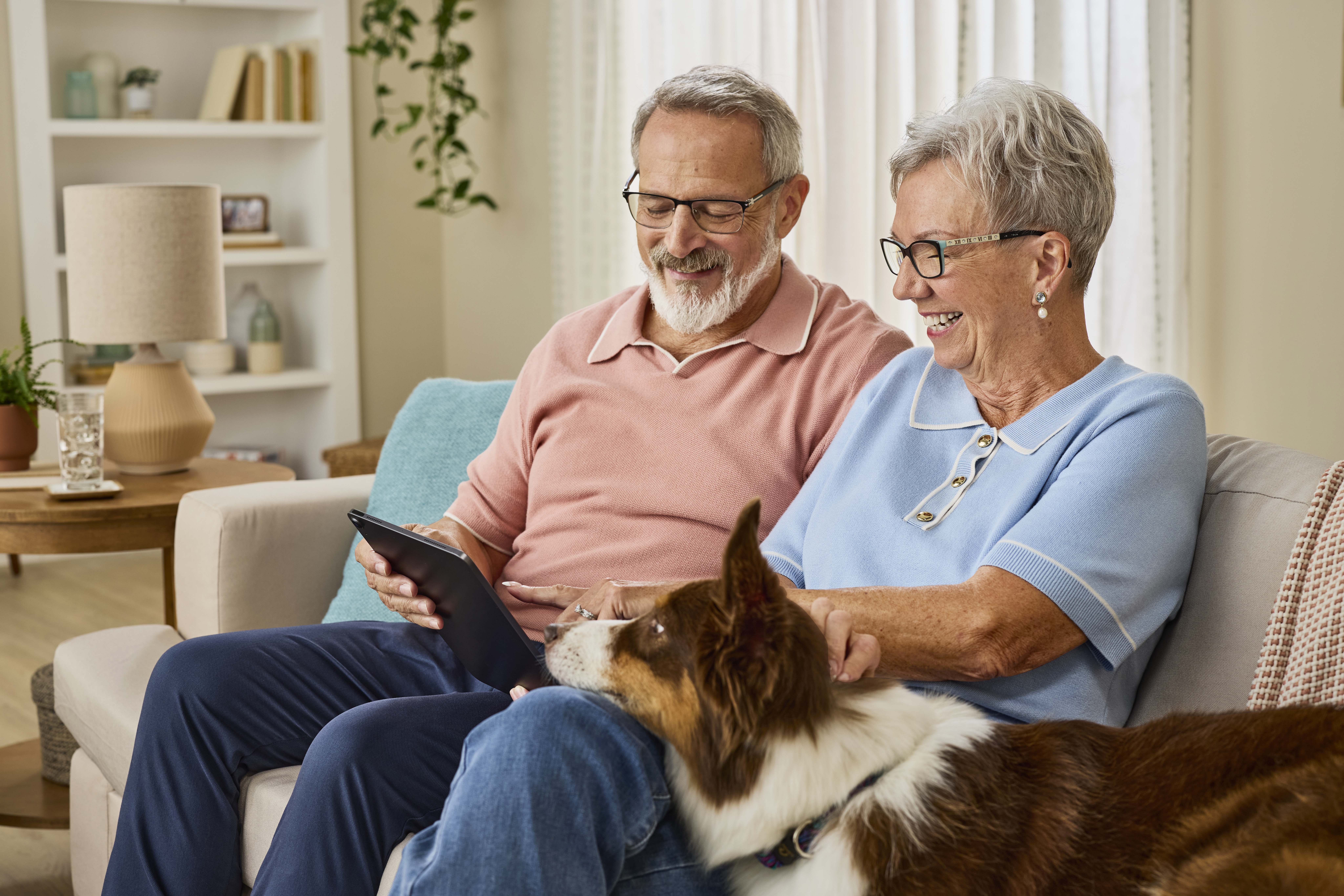 Pareja de personas mayores mirando una carta​​ 