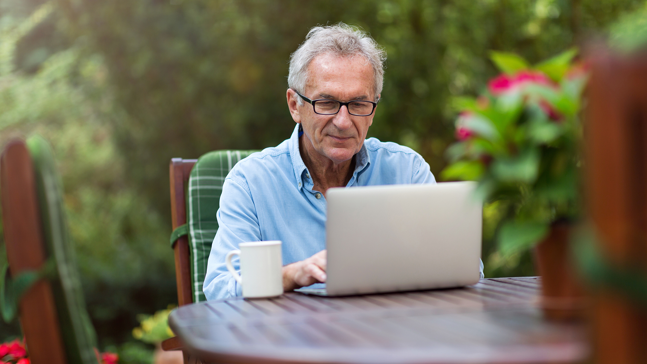 Hombre mayor trabajando con una laptop al aire libre​​ 