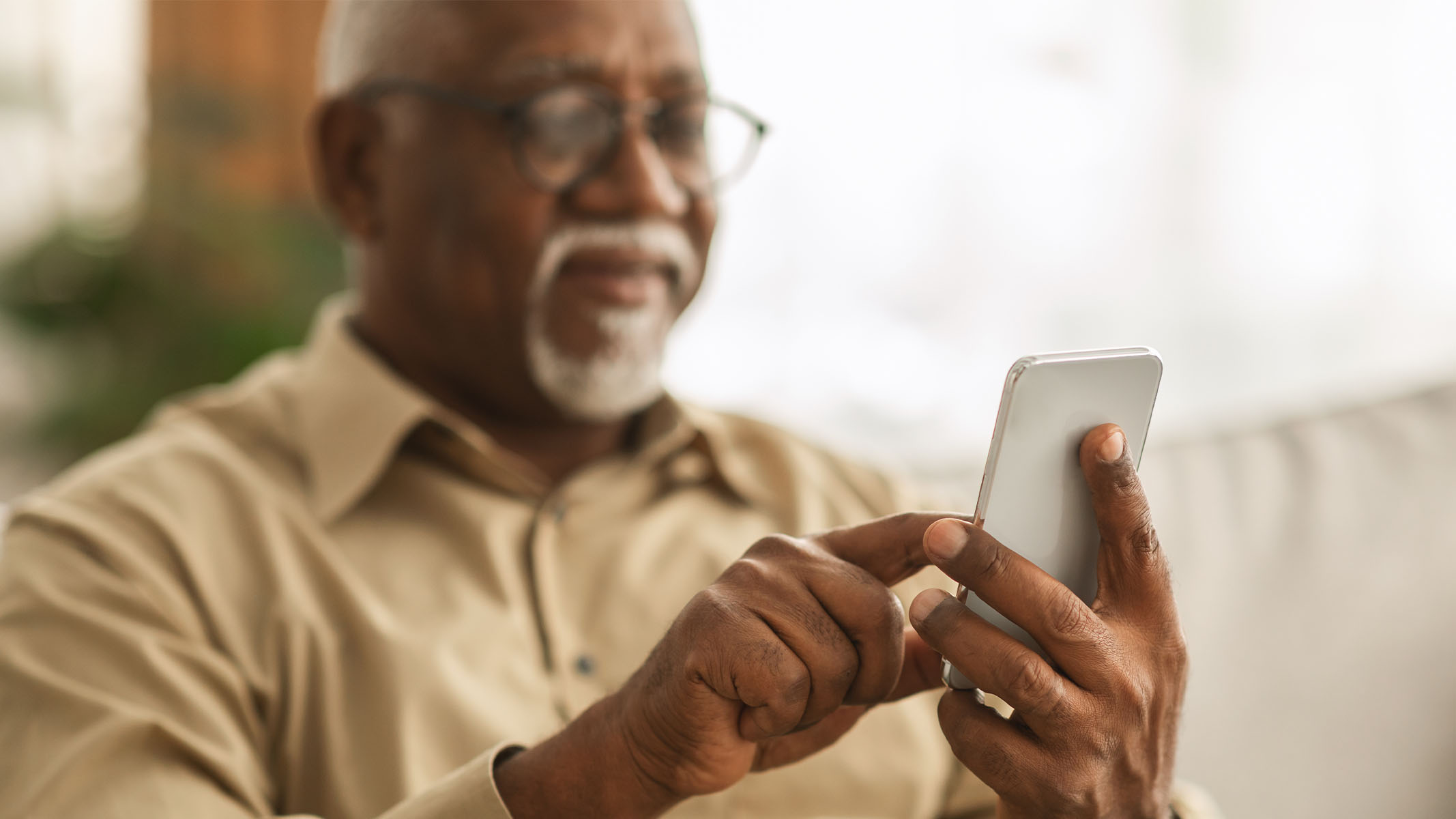 Un hombre mayor usando un smartphone.​​ 