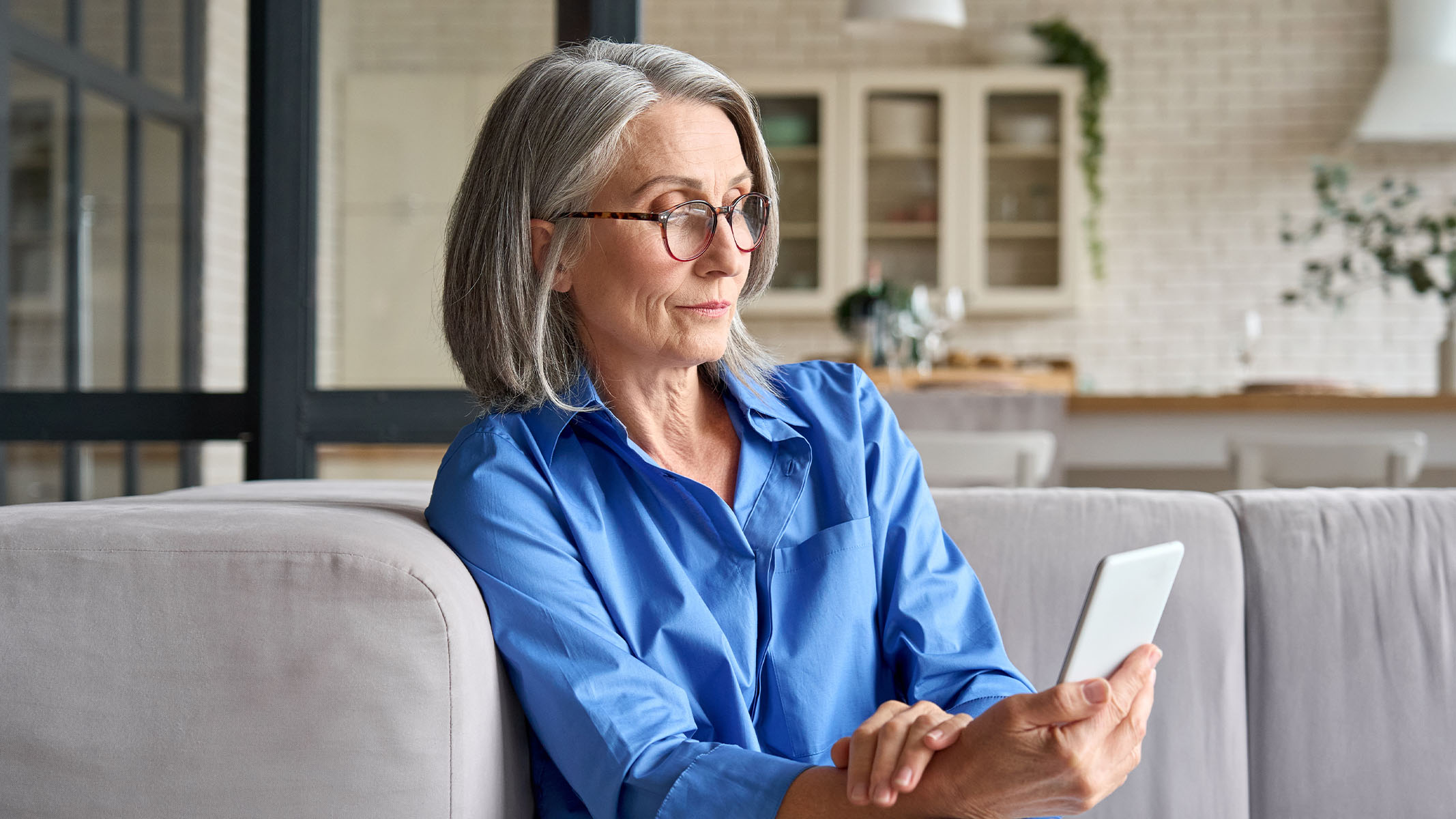 Mujer mayor mirando el smartphone.​​ 
