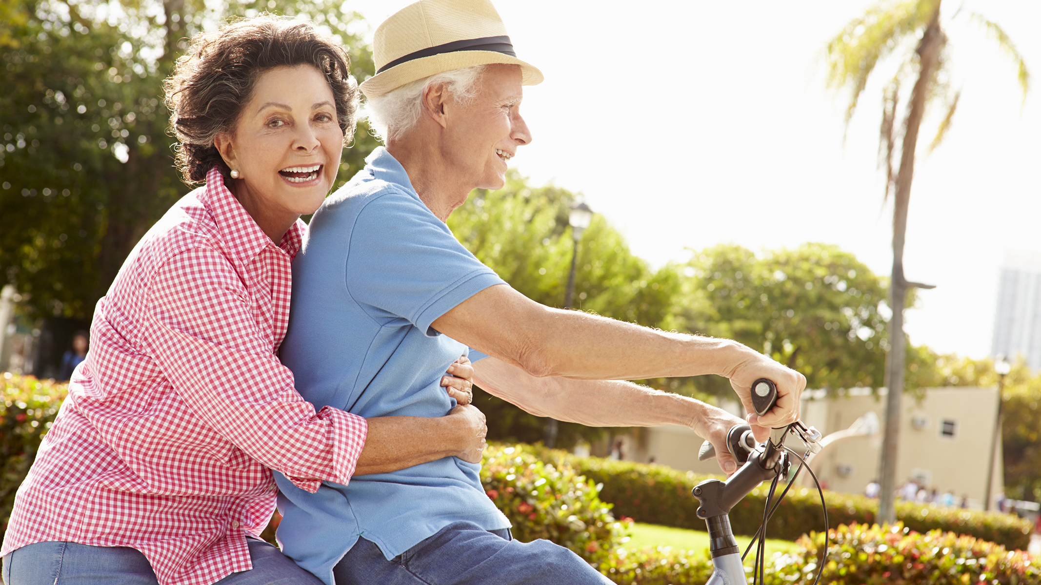 Pareja de personas mayores andando en bicicleta.​​ 