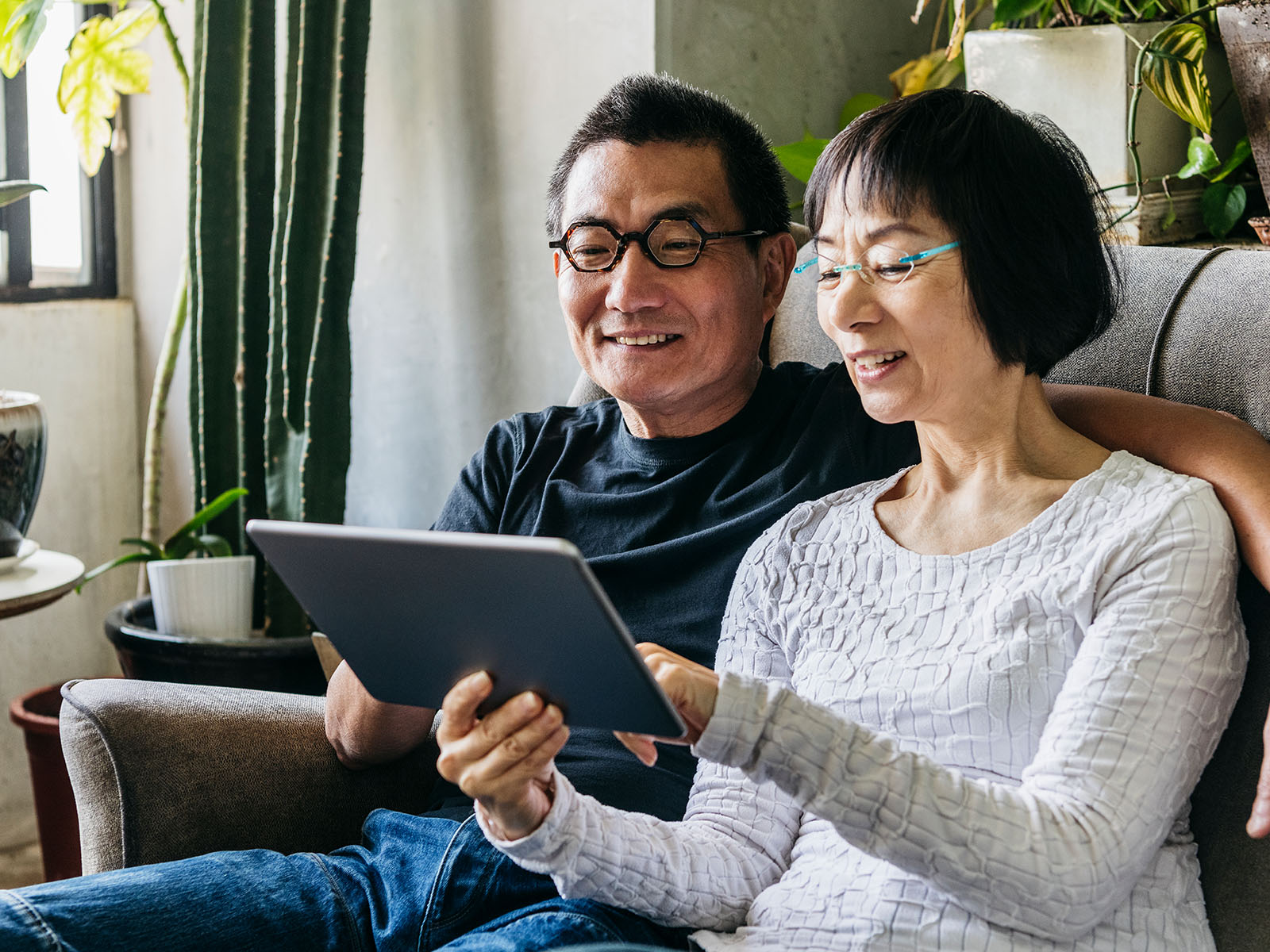  Una pareja de personas mayores usando una tablet.​​ 
