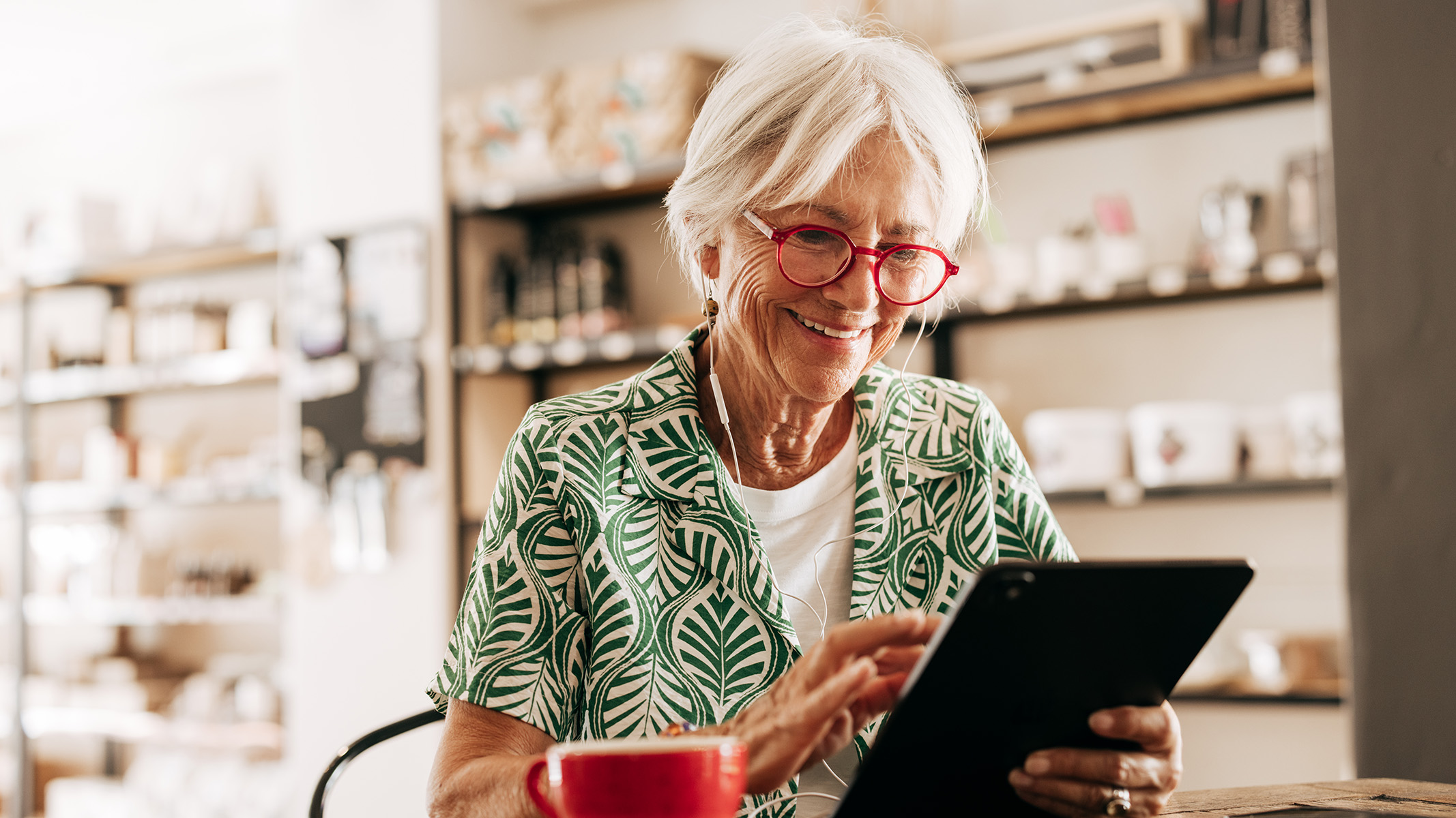 Senior woman reading on a tablet.​​ 